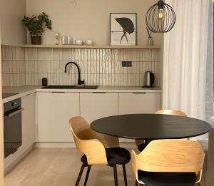 cocina con mesa, sillas y fregadero en 3 izbový apartmán hneď pri letisku, možnosť rezervovať parking, en Prievoz