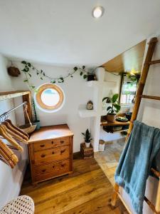 a bathroom with a wooden dresser and a round window at Bali-Style Tinyhaus am Wald in Bruckberg