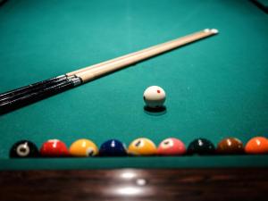 a cue and balls on a pool table at KAMENOI HOTEL Kusatsu Yubatake in Kusatsu