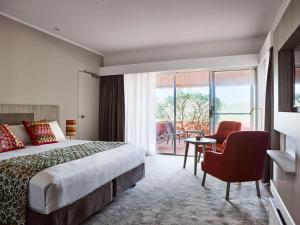 a hotel room with a bed and a table and a chair at Desert Gardens Hotel in Ayers Rock