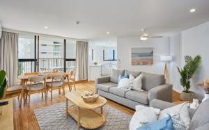 Horizons Holiday Apartments - OFFICIAL في غولد كوست: غرفة معيشة مع أريكة وطاولة