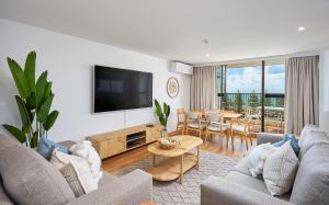Horizons Holiday Apartments - OFFICIAL في غولد كوست: غرفة معيشة مع أريكة وتلفزيون
