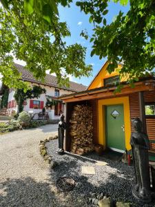 a house with a green door and a stone wall at Bali-Style Tinyhaus am Wald in Bruckberg