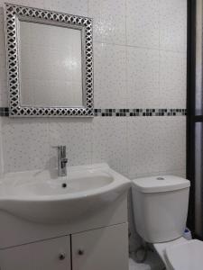 uma casa de banho com um lavatório, um WC e um espelho. em CABAÑAS 88 Y 8 em Coñaripe