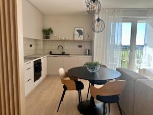 cocina y sala de estar con mesa y sillas en 3 izbový apartmán hneď pri letisku, možnosť rezervovať parking en Prievoz