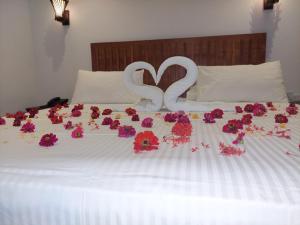 Una cama con rosas y un par de corazones. en J7 Villaj Resort en Trincomalee