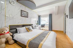a bedroom with a large bed and a teddy bear at Villa Hẻm Đà Lạt in Da Lat