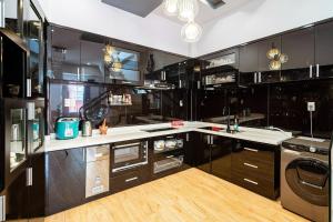 a kitchen with black cabinets and white counter tops at Villa Hẻm Đà Lạt in Da Lat