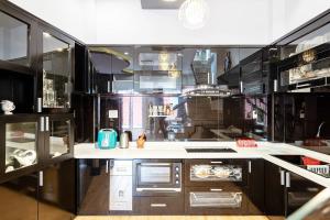 a kitchen with black cabinets and a white counter top at Villa Hẻm Đà Lạt in Da Lat +13 photos