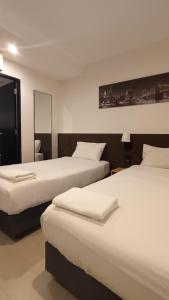 曼谷The Blocks Hostel Sukhumvit 10的有两张床和一面镜子的酒店房间