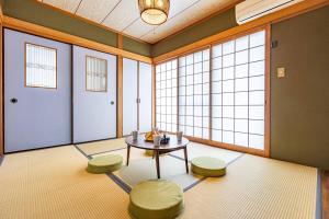 Habitación con mesa, 2 taburetes y ventanas en Azami Ann Maisonette, en Shirahama