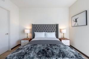 a bedroom with a large bed with two lamps at New WeHo Luxury Apartment in Los Angeles