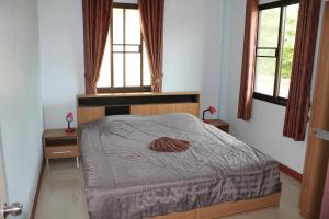 1 dormitorio con 1 cama y 2 ventanas en Naluemon Village FH 3-4 en Ban Phe