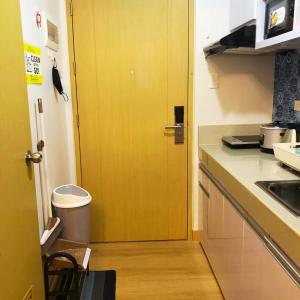 a yellow door in a kitchen with a counter at Osam Empire Studio 1 @Trees Residences in Manila