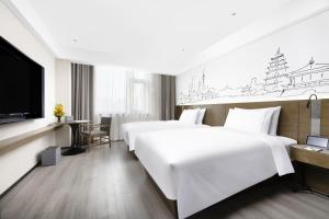 a hotel room with two beds and a flat screen tv at UrCove by Hyatt Xi'an Hi-Tec in Xi'an