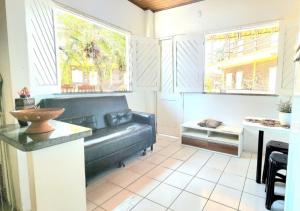 ein Wohnzimmer mit Sofa und Tisch in der Unterkunft Chalé Descanso - Cond Porto dos lençois Barreirinhas in Barreirinhas