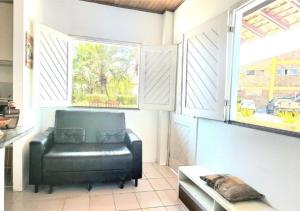 ein schwarzer Ledersessel in einem Zimmer mit Fenster in der Unterkunft Chalé Descanso - Cond Porto dos lençois Barreirinhas in Barreirinhas + 26 Fotos