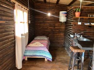 Habitación pequeña con cama en una casa de madera en CABAÑAS COSTA RIBERA en Timbúes