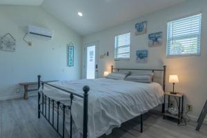a bedroom with a bed and two windows at Blue Oasis minutes from the beach with Gameroom! in Corpus Christi