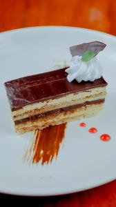 un trozo de pastel de chocolate en un plato blanco en Ragazzi Resort Hotel, en Naga