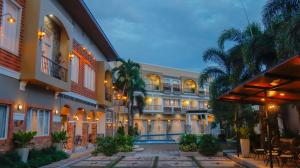 ein Hotel mit einem Innenhof mit Stühlen und Palmen in der Unterkunft Ragazzi Resort Hotel in Naga