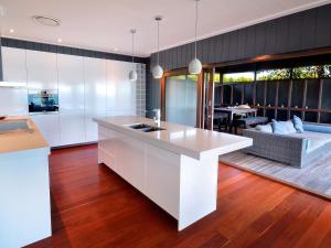 a kitchen with a white counter and a living room at Dolphins at Sunset in Amity Point