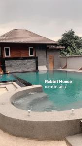 a swimming pool in front of a house at Rabbit House in Ban Han Tra Fang Nua