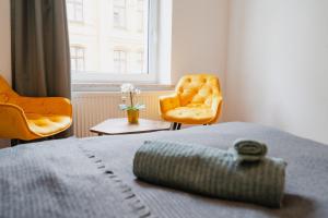 1 Schlafzimmer mit einem Bett, 2 Stühlen und einem Fenster in der Unterkunft Blue Chili 02 - MD Zentral City Carré Wlan Netflix in Magdeburg