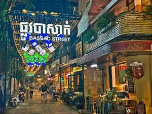 Times Hotel at Bassac Lane في بنوم بنه: الناس يسيرون في شارع في مدينة في الليل