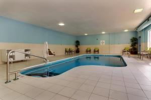 a swimming pool in a large room with tables and chairs at Holiday Inn Express Hotel & Suites Dayton-Centerville by IHG in Centerville