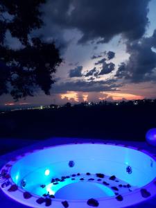 a jacuzzi tub with a sunset in the background at Happy Glamping Quindio - Tipo Domo Traslúcido in Calarcá