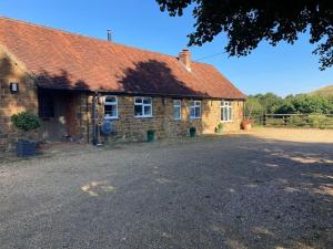 a brick house with a red roof and a driveway at Spacious Cottage in Idyllic Spot in Fenny Compton