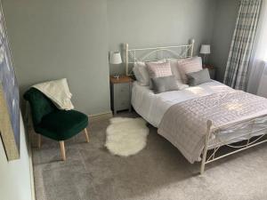 a bedroom with a bed and a chair and a rug at Spacious Cottage in Idyllic Spot in Fenny Compton
