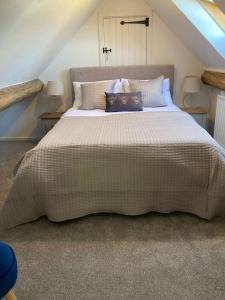 a bedroom with a large bed with pillows on it at Spacious Cottage in Idyllic Spot in Fenny Compton