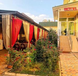 a store with red and yellow drapes and plants in front at Гостиничный комплекс Жеты Казына in Zharkent