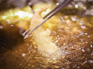 音更町にある笹井ホテルの海老を箸で鍋に入れて調理中