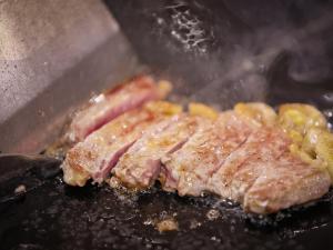 dois pedaços de carne cozidos numa grelha em Sasai Hotel em Otofuke