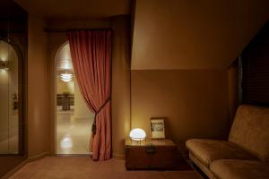 a living room with a couch and a red curtain at Amid Hotel Seoul in Seoul