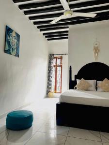 a bedroom with a bed and a ceiling fan at Villa Euphoria - Adults Only in Paje