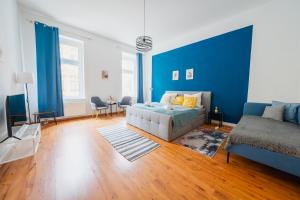 a blue bedroom with a bed and a couch at Blue Chili 02 - MD Zentral City Carré Wlan Netflix in Magdeburg