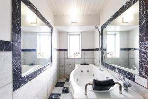 een badkamer met een bad en een grote spiegel bij PRIME in Sapporo