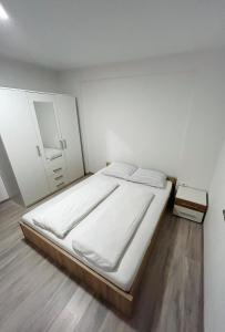 a white bedroom with a bed and a mirror at Perfect Place for two in Kranj