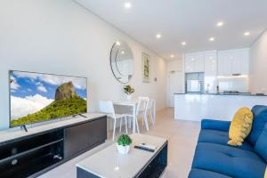 a living room with a blue couch and a tv at Comfort Two bedroom Apartment with Free parking In Valley in Brisbane