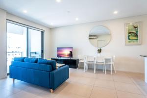 een woonkamer met een blauwe bank en een tafel bij Comfort Two bedroom Apartment with Free parking In Valley in Brisbane