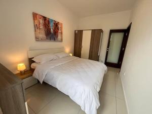 sypialnia z białym łóżkiem i lustrem w obiekcie Cosy 2Bedroom 1 min walk away from the sea apartment 1 w Gżirze