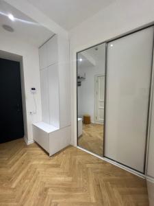 einen großen Spiegel in einem Zimmer mit Holzboden in der Unterkunft Axis Towers 1 bedroom 4 guests! in Tbilisi City
