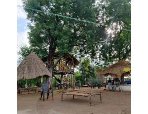 a playground with a tree and a wooden table and chairs at Rekha & Kamla Homestay, Orchha 