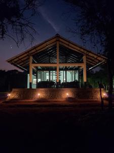 a large building with lights in front of it at night at Forest Edge Bungalow - Wilpattu in Radagama