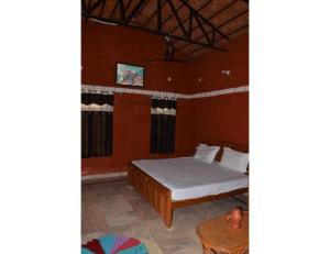 a bedroom with a bed and a table in a room at Rekha & Kamla Homestay, Orchha 
