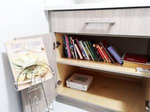 a book shelf filled with books next to a drawer at Lucy's Place - Two Bedroom Suite in Vancouver